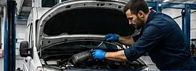Technician working under the bonnet of a van